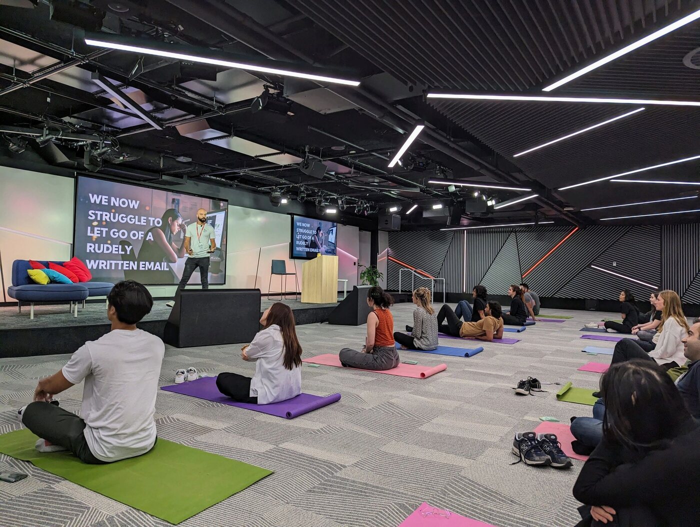 Daniel Augustine leading a workplace breathwork session for employees seated on mats at Google.