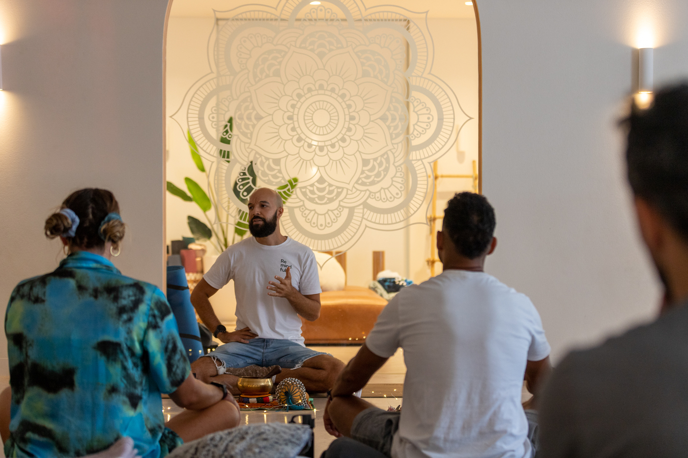 A Be Remindful facilitator resting a hand gently on a participant's shoulder during a guided breathwork session.