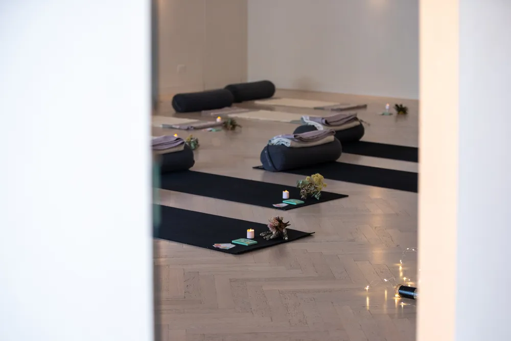 Breathwork mats prepared with cushions, blankets, cards and candles